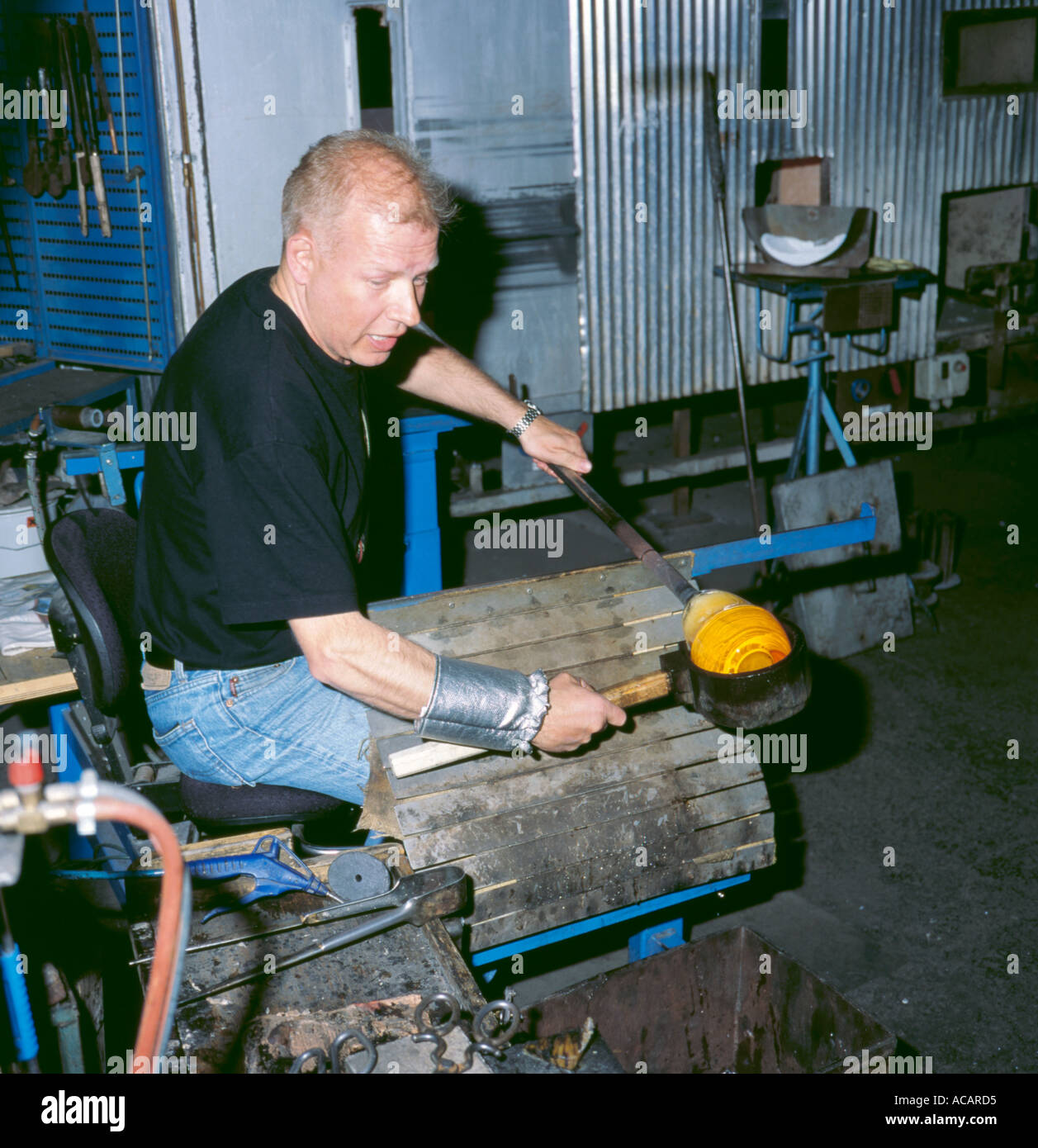 Glass maker working hot glowing glass straight from the furnace, Kosta