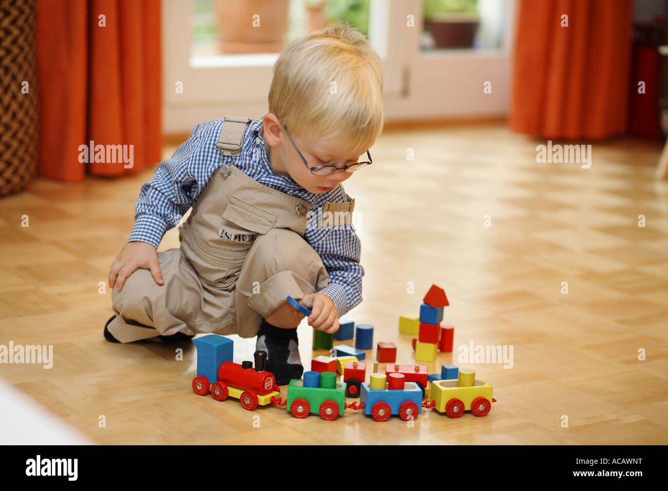 Little boy plays with a wooden toy-train Stock Photo