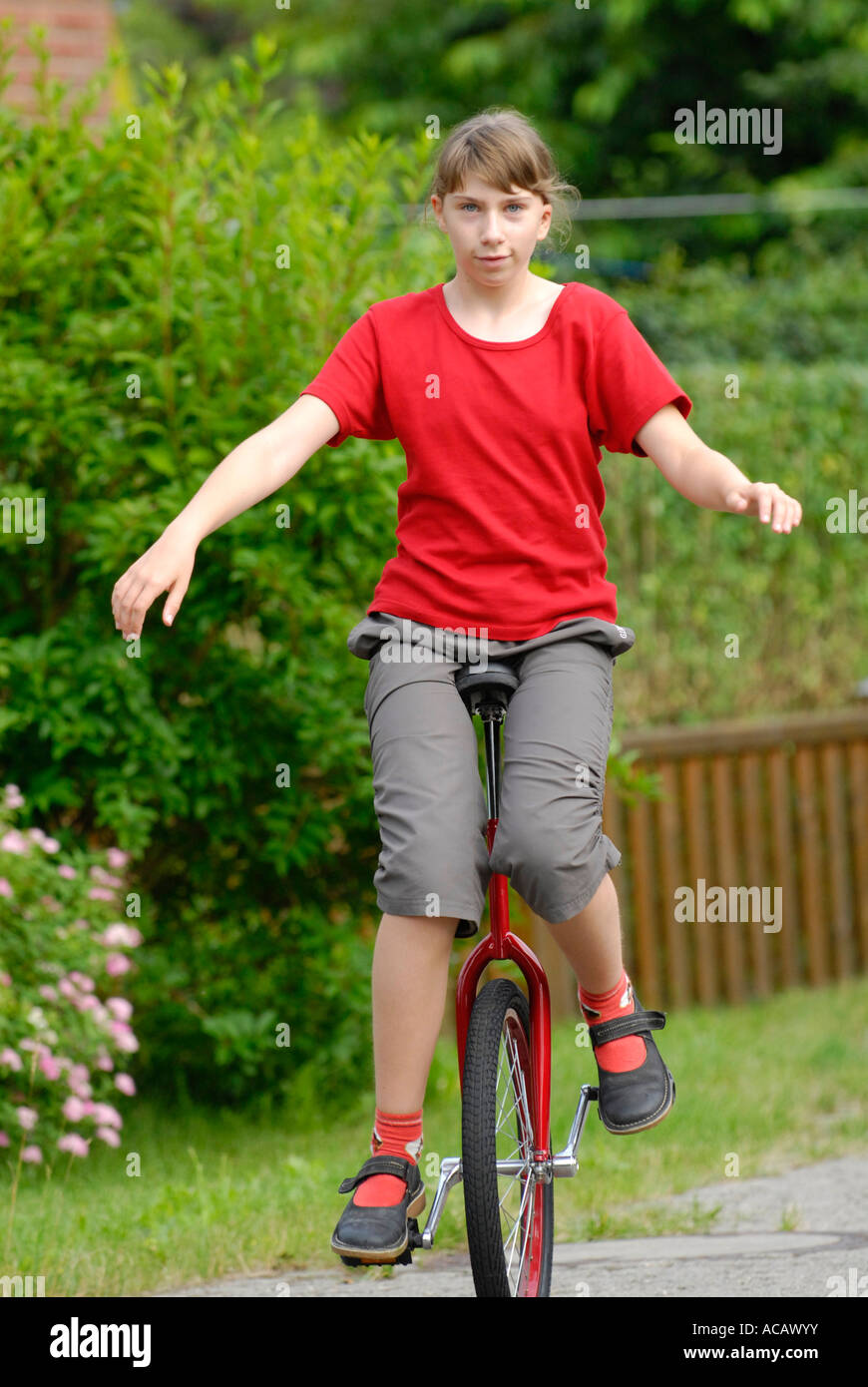 Girl practices unicycle driving on a sideway Stock Photo