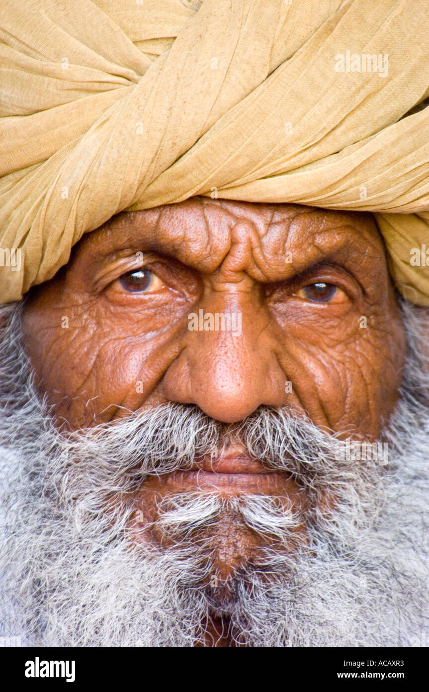 Close up portrait of a wrinkled old Indian man with a grey beard and turban on his head at the Mehrangarh Fort in Jodhpur. Stock Photo