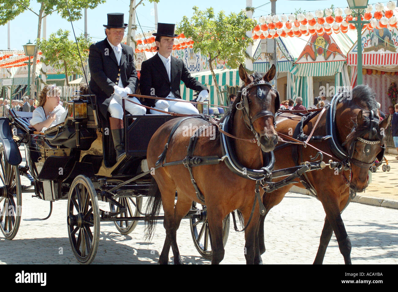 Coach and pair with coachmen in traditional dress driving through the