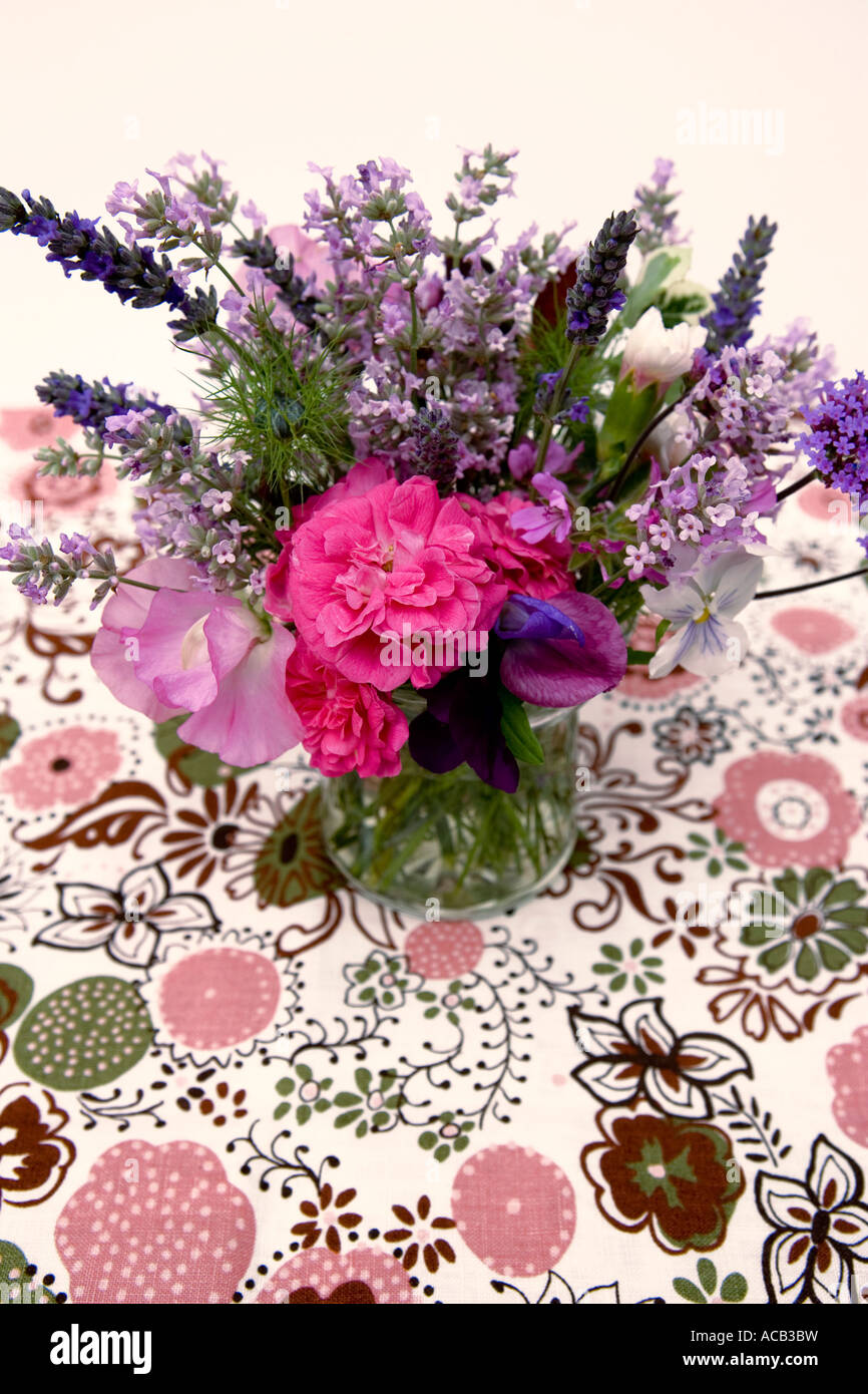 Cut flowers on a floral table cloth Stock Photo