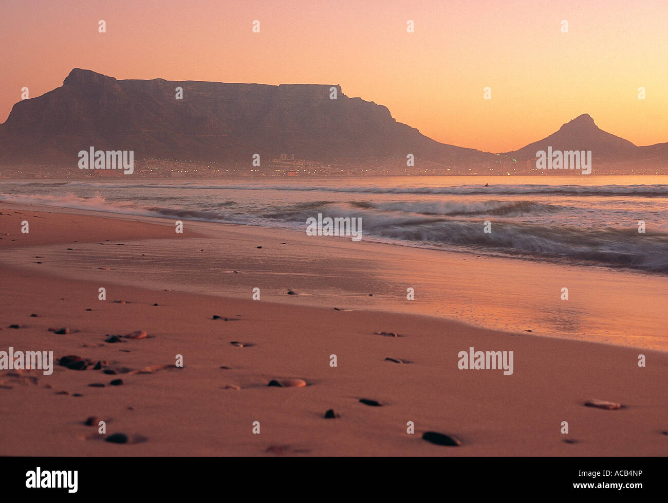 Table Mountain and Cape Town at sunset from Milnerton Beach South Africa This is a warm colourful moody scene Stock Photo