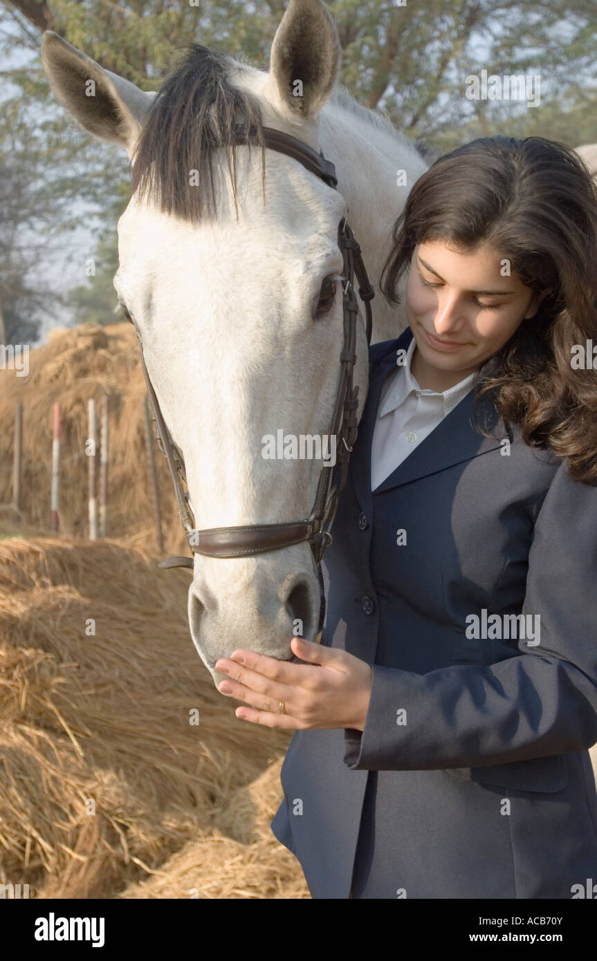 Teenage girl standing with a horse Stock Photo - Alamy