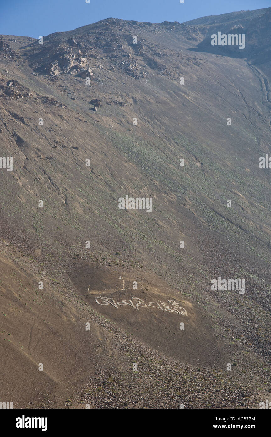 India Himachal Pradesh Spiti Tabo steep dark mountain side with mantra written with with stones Stock Photo