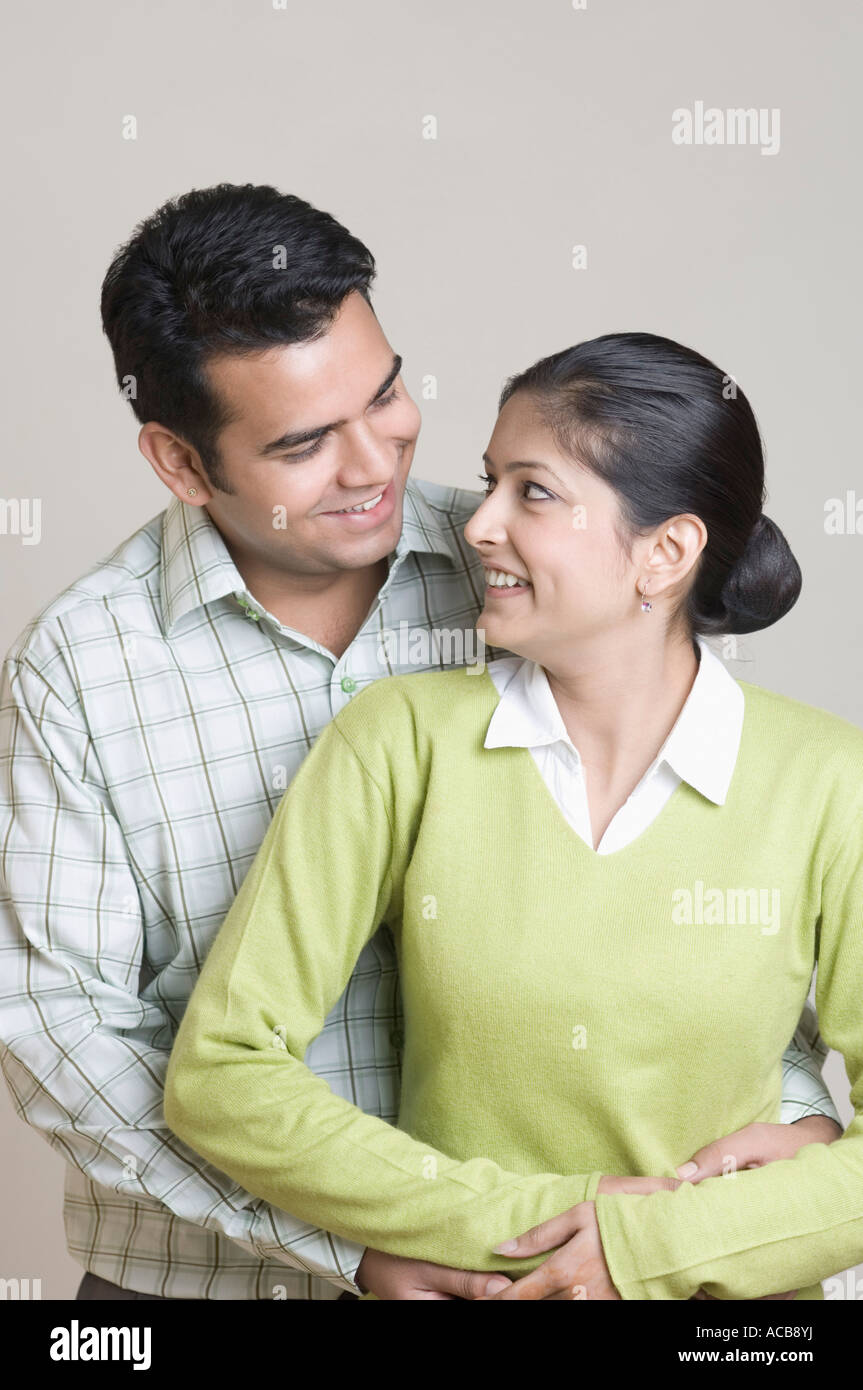 Young man embracing a young woman from behind Stock Photo - Alamy
