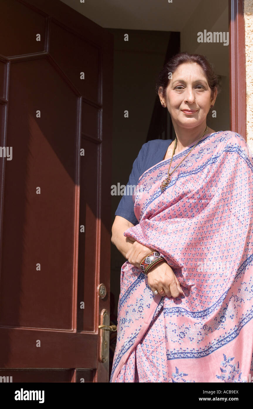 Portrait of a mature woman standing at the doorway Stock Photo - Alamy