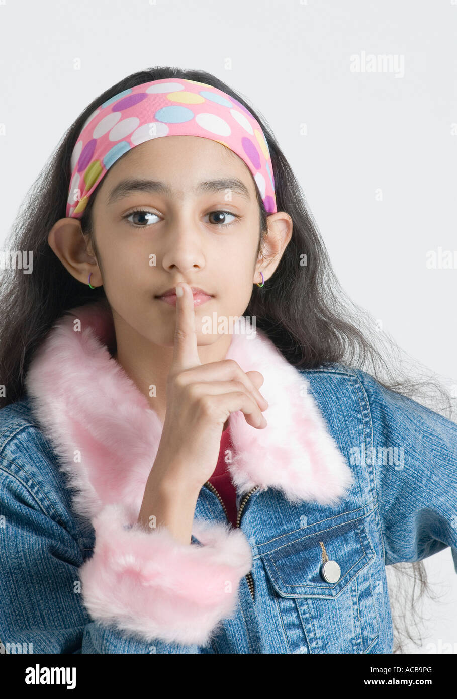 Portrait of a girl with her finger on her lips Stock Photo - Alamy