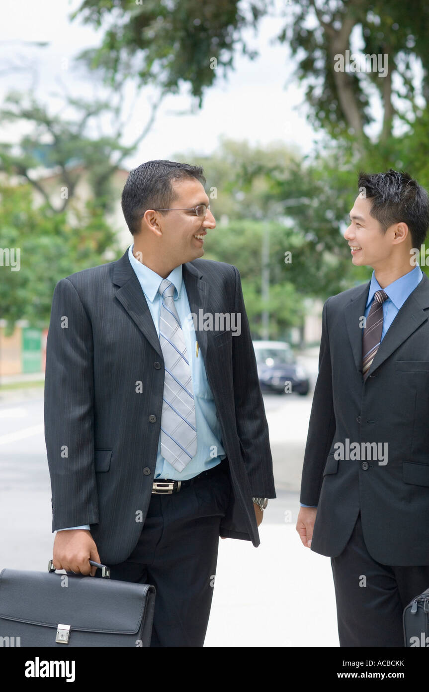 Two businessmen looking at each other and smiling Stock Photo - Alamy
