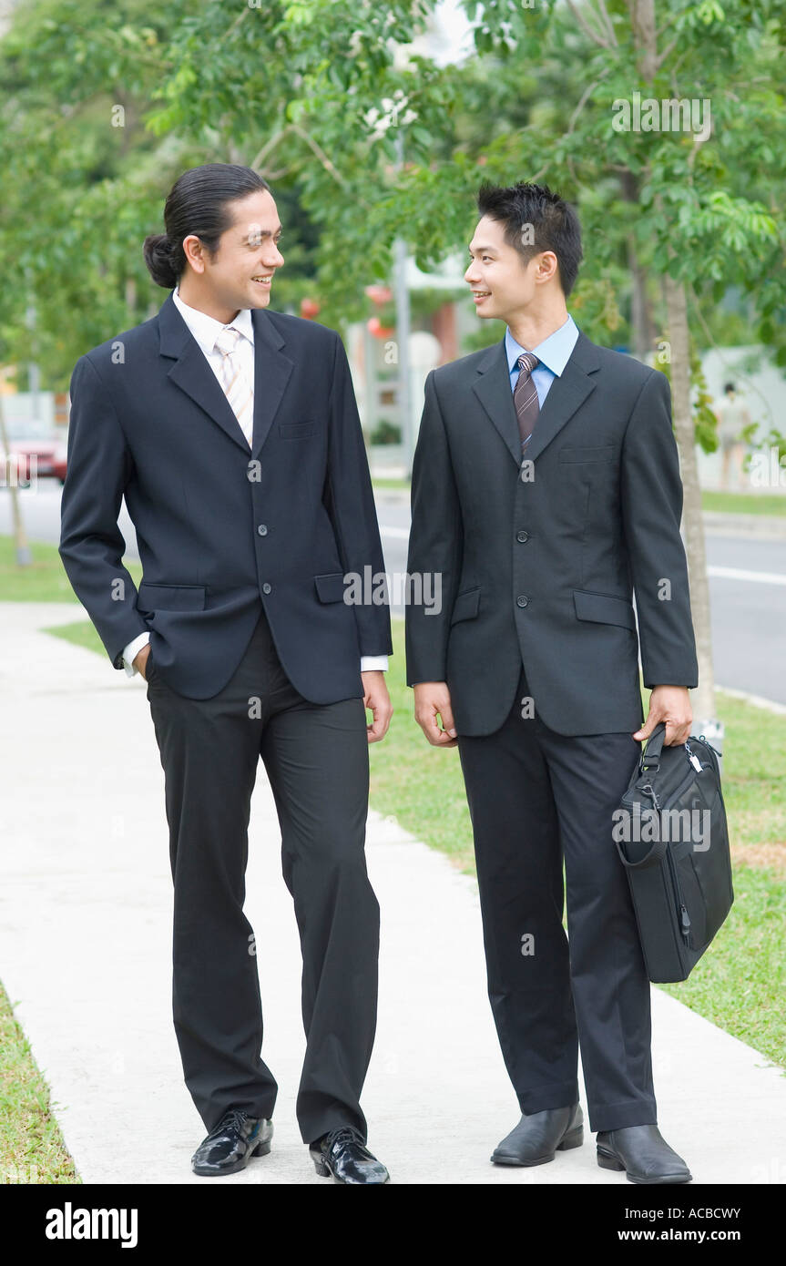 Two businessmen looking at each other and smiling Stock Photo - Alamy