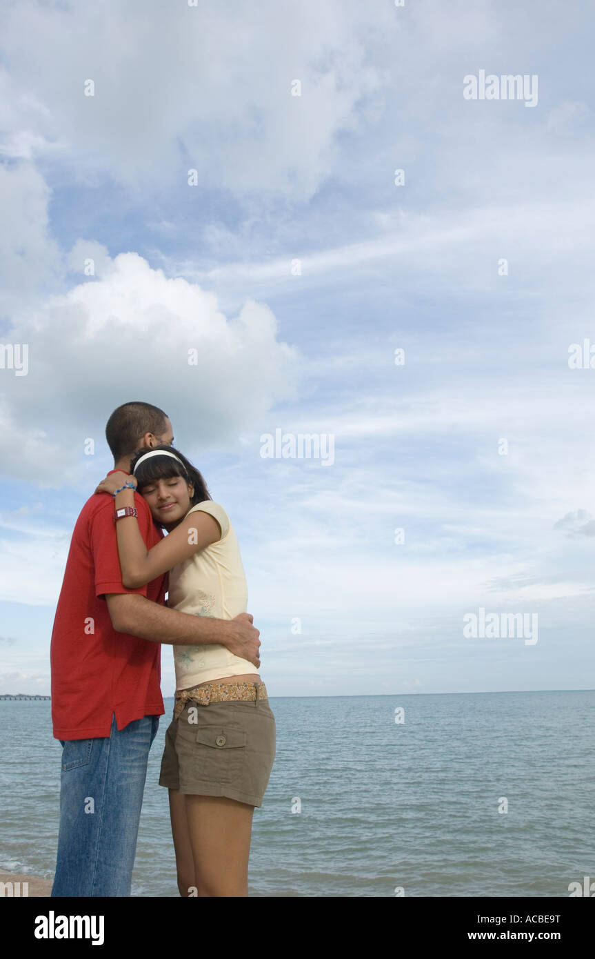 Mid adult woman and a young man embracing each other on the beach Stock ...