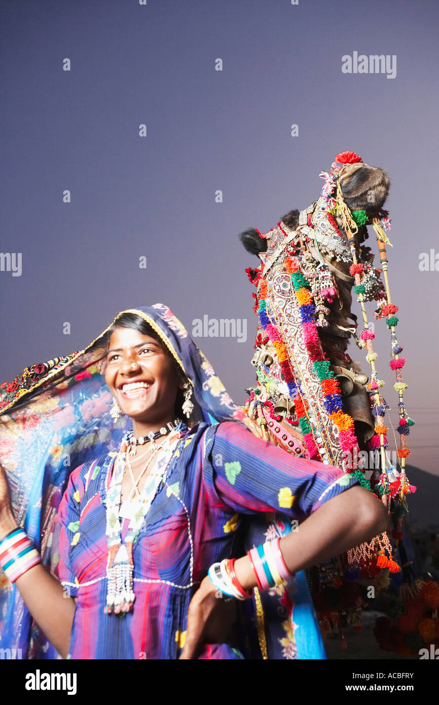 Young woman standing with her hand on her hip and smiling Stock Photo ...