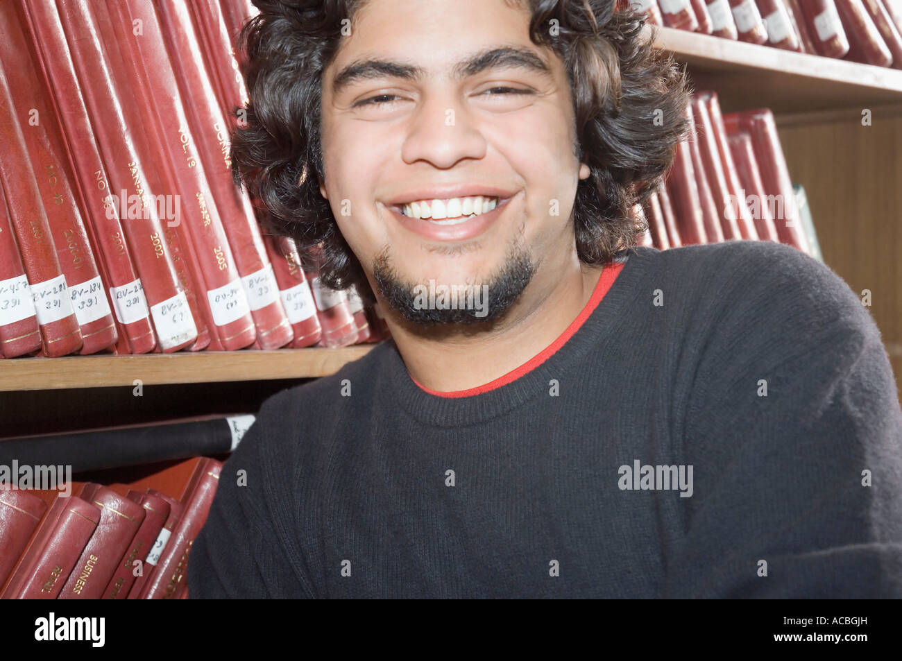 Portrait of a male college student in a library and smiling Stock Photo ...