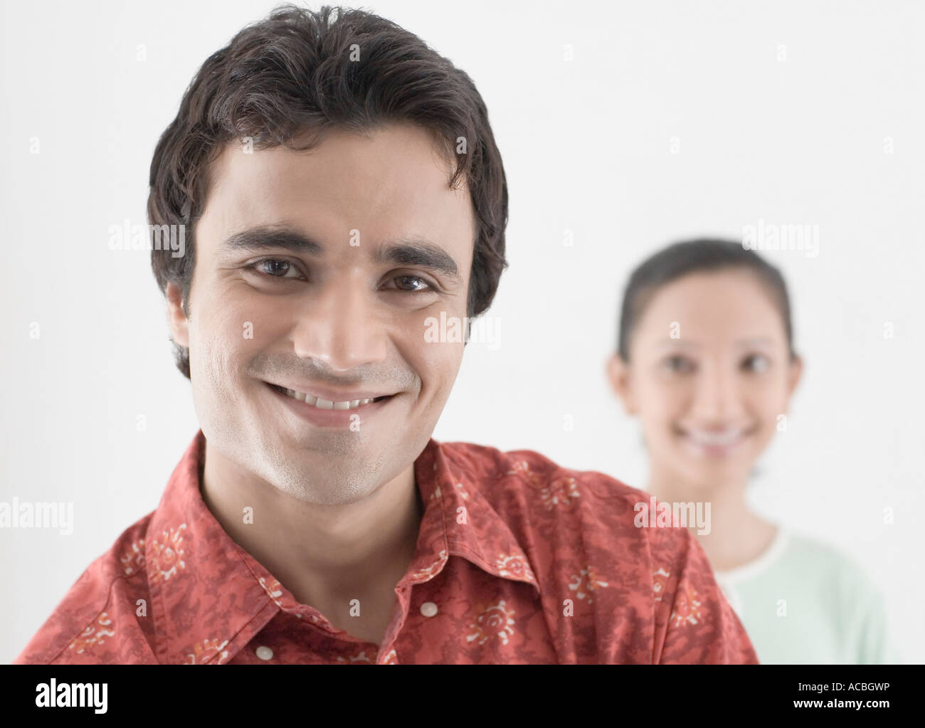 Portrait of a young man smiling with a young woman smiling in the ...