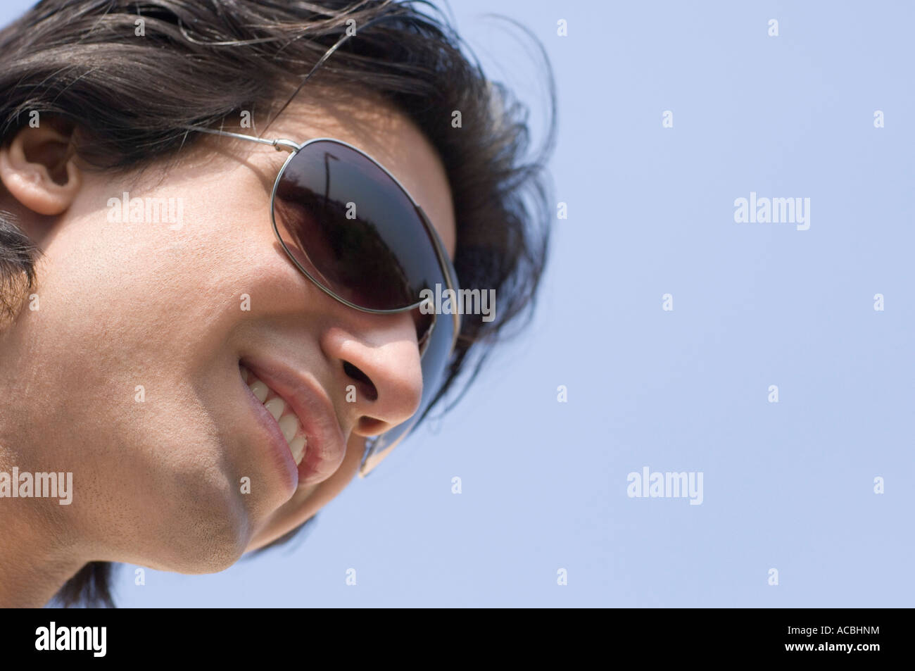 Close-up of a young man wearing sunglasses and smiling Stock Photo