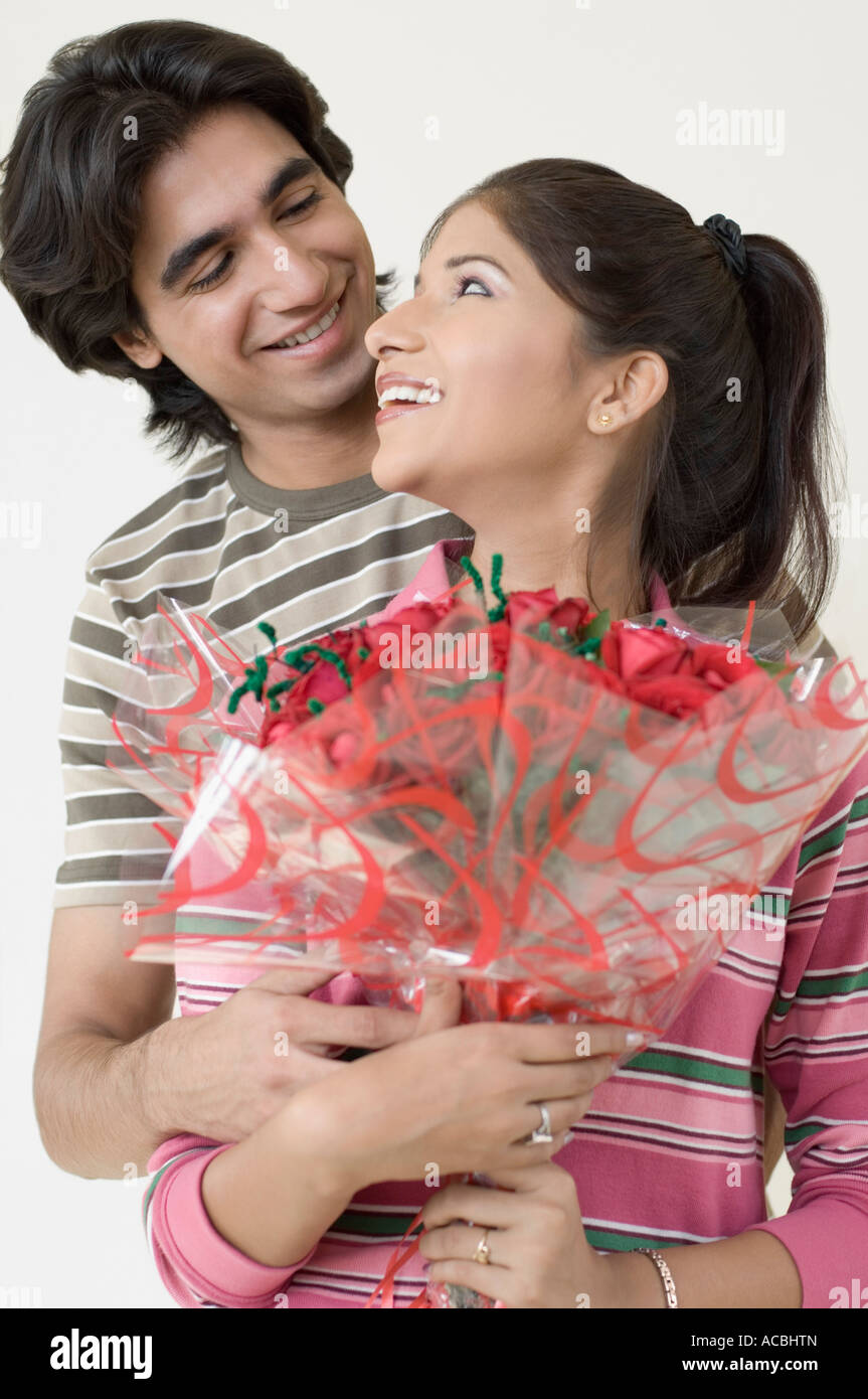 Close-up of a young man embracing a young woman from behind Stock Photo ...