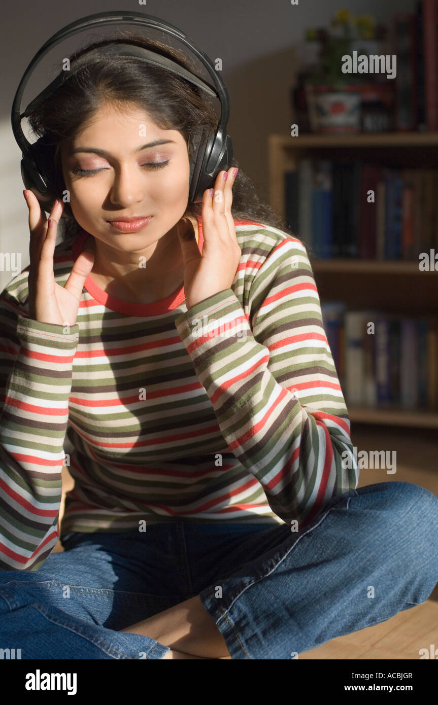 Young woman sitting on the floor and listening to music Stock Photo - Alamy