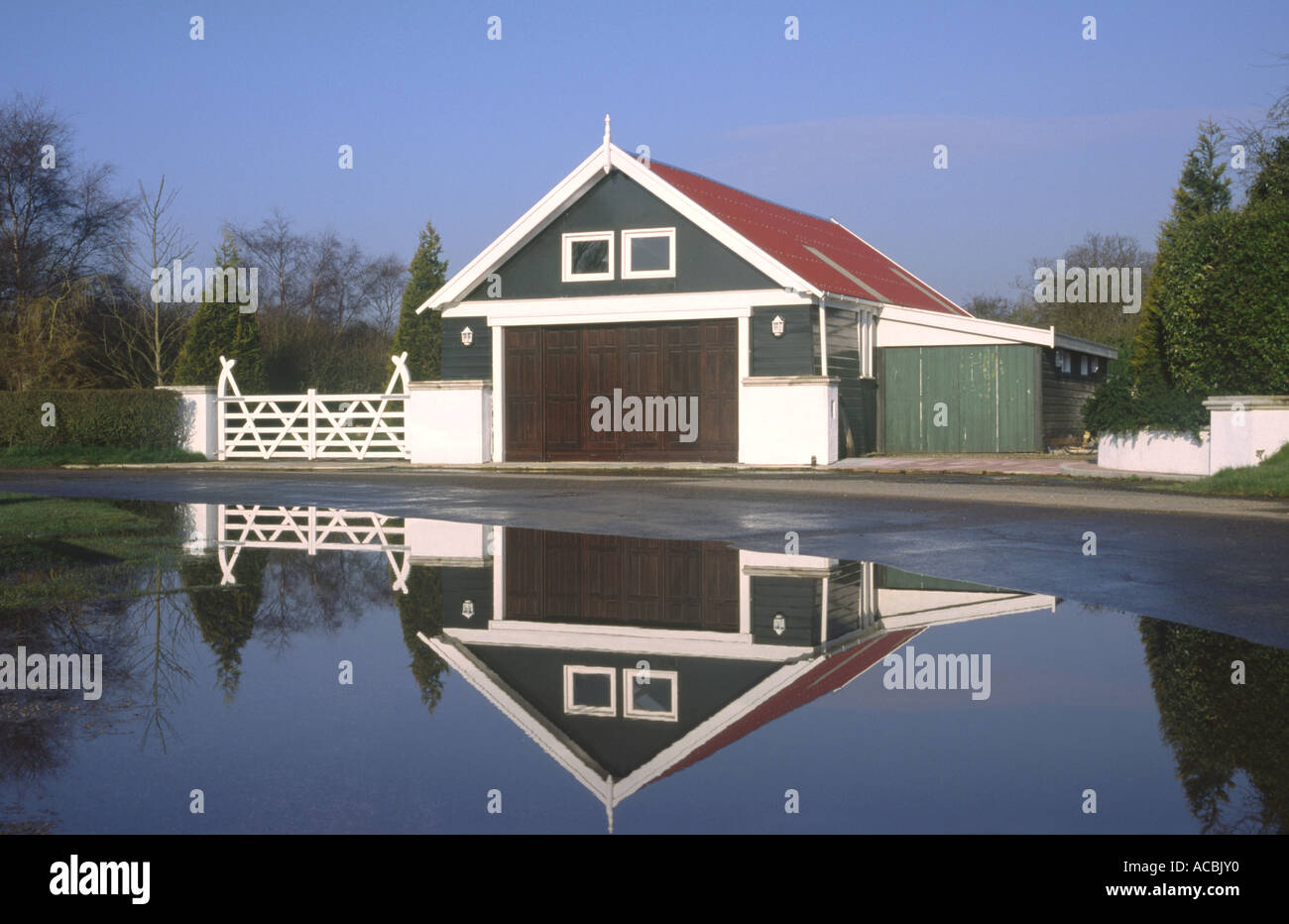 Reflection Of Garage Building In Large Puddle Uk Stock Photo