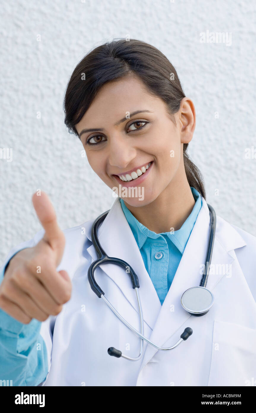 Portrait of a female doctor making a thumbs up sign Stock Photo - Alamy