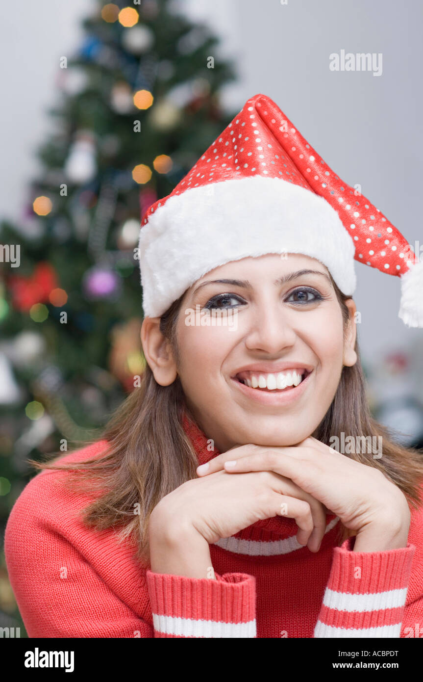 Portrait of a young woman wearing a Santa hat and smiling Stock Photo ...