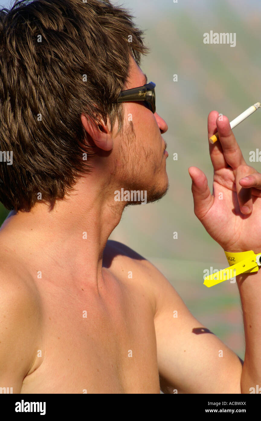 Bare chest teenage man dancing and smoking cigarette at rave party Hilltop  2007, Slovakia Stock Photo
