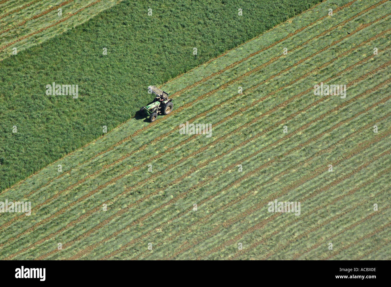 Aerial photo of farmer on tractor harvesting alfalfa Stock Photo - Alamy