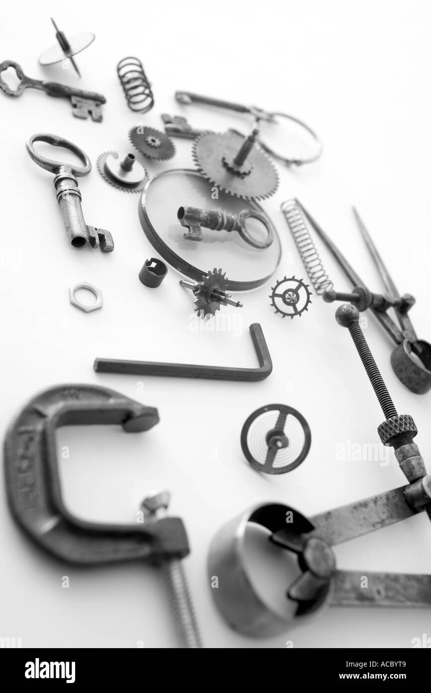 Tools and small objects keys and cogs form a pattern on a white backdrop Stock Photo