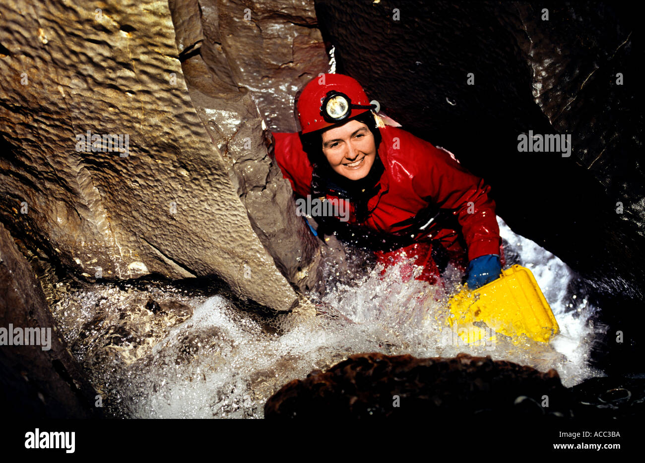 Female caver in a wet streamway Wales cave UK Stock Photo