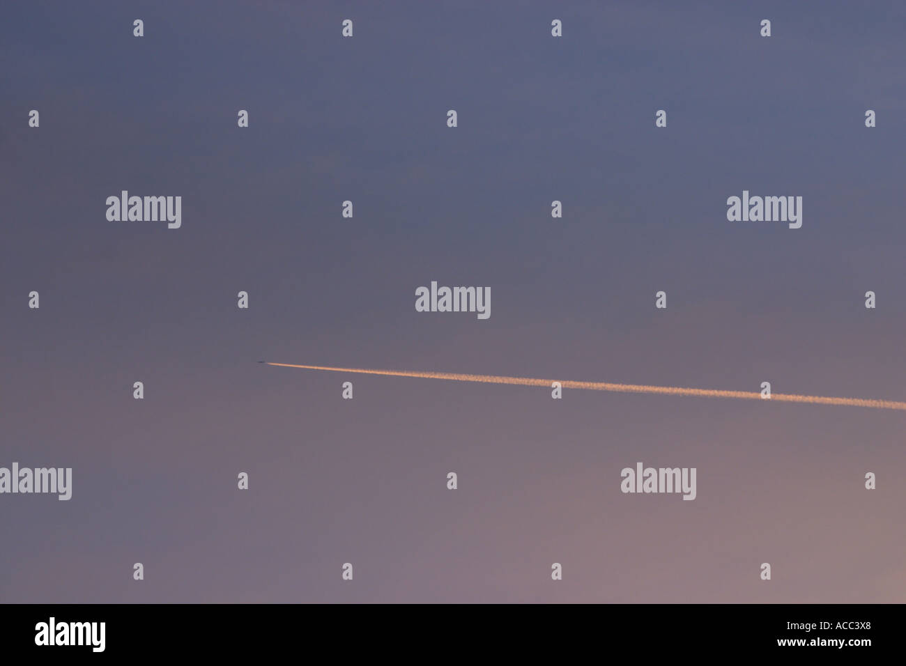 plane contrail across evening sky Stock Photo