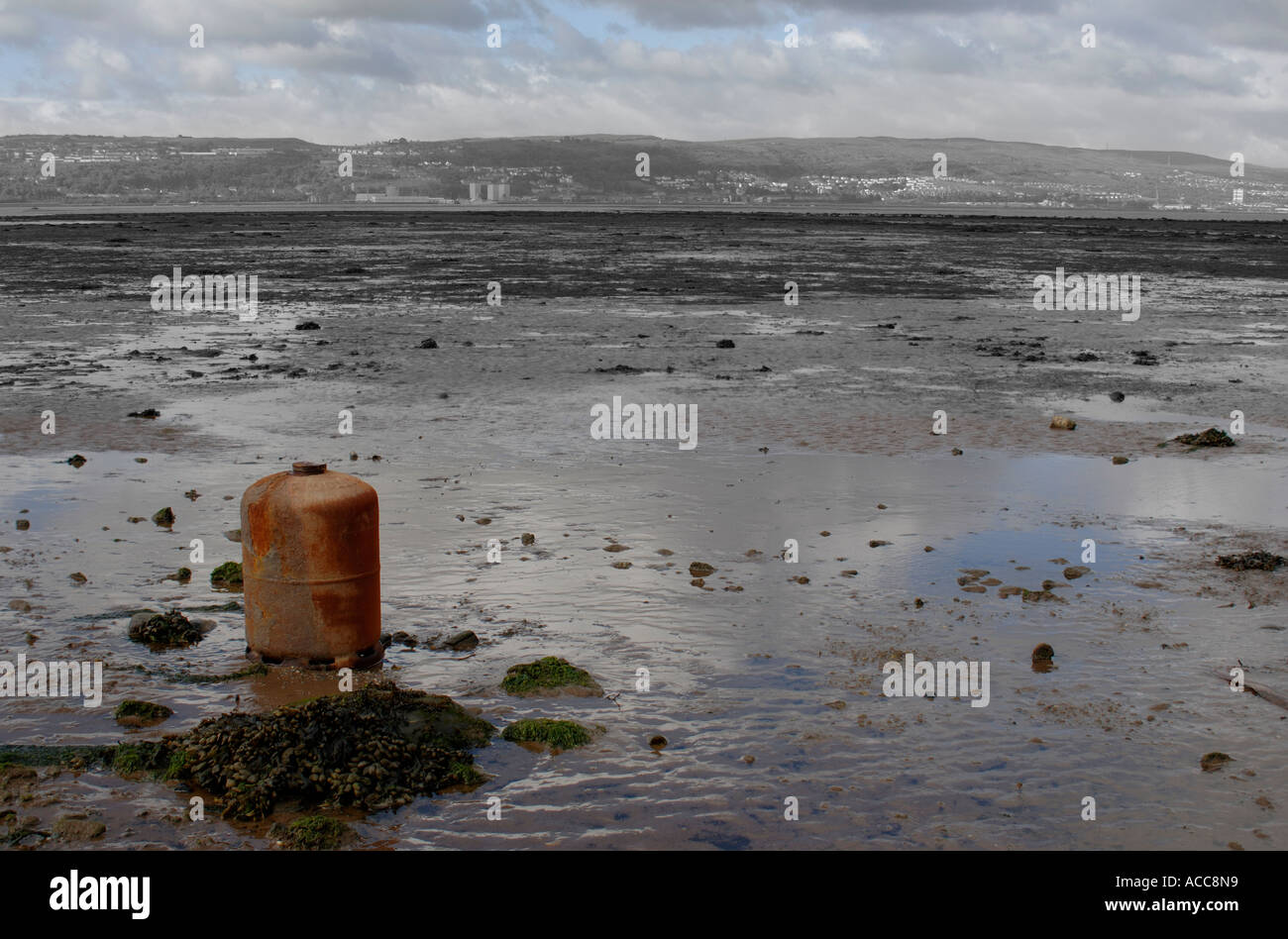 The River Clyde estuary shoreline with old gas canister embedded in mud at Cardross, Scotland
