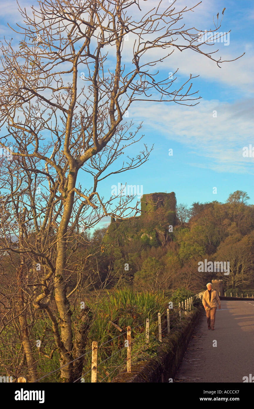 Evening light pedestrian waling on road below Dunollie Castle Oban