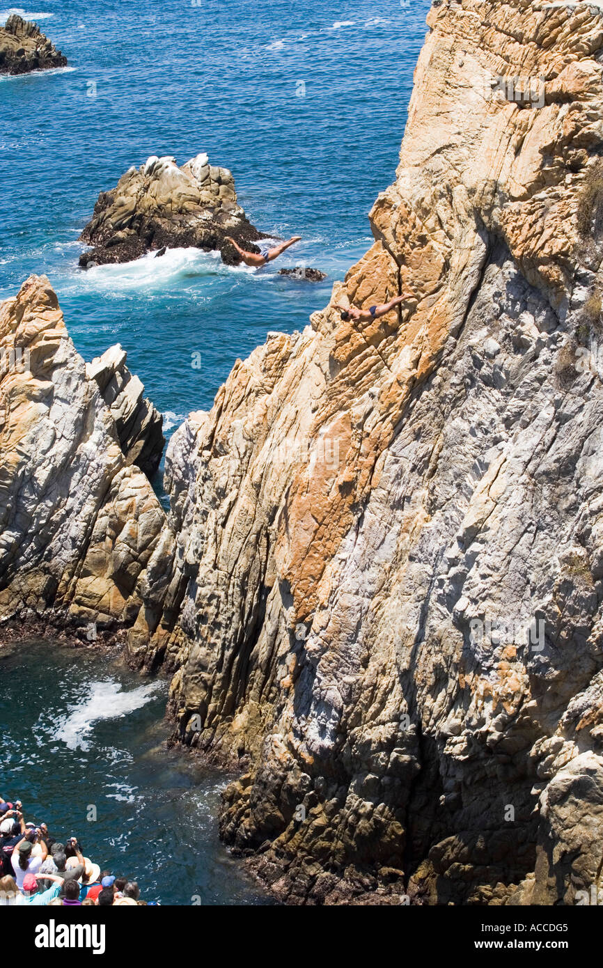 Cliff diving in Acapulco Mexico with two cliff divers in the air Stock