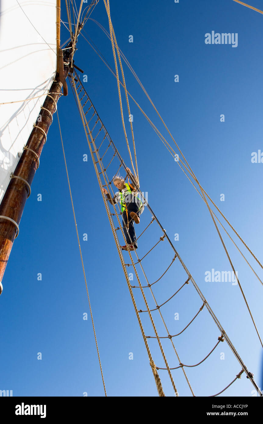 A person climbing up on a rope ladder on a sailing ship Stock Photo - Alamy