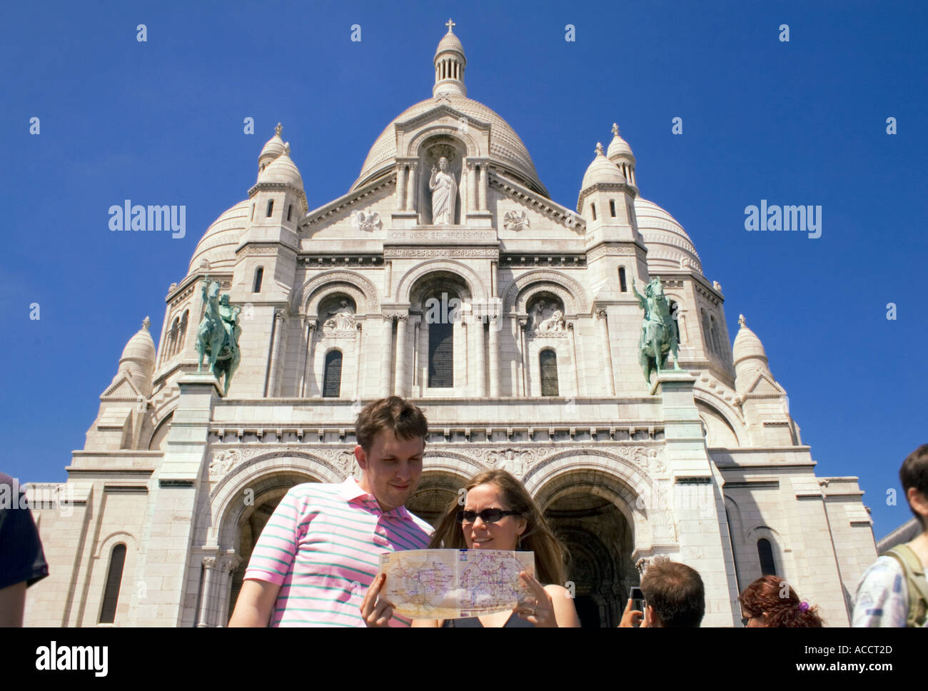 Tourists looking at a metro map in front of Sacre Ceaur in Paris France Stock Photo