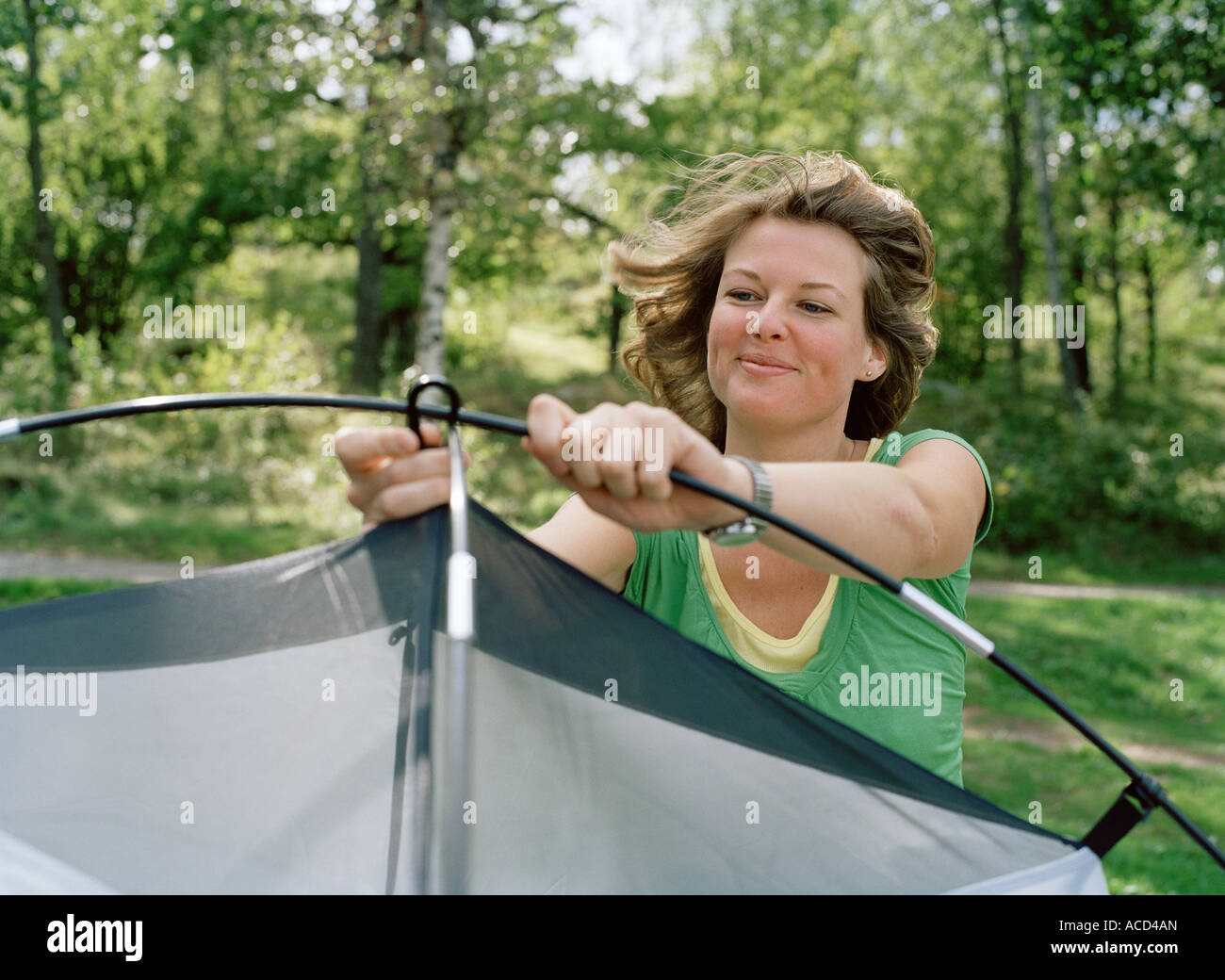A woman setting up a tent. Stock Photo