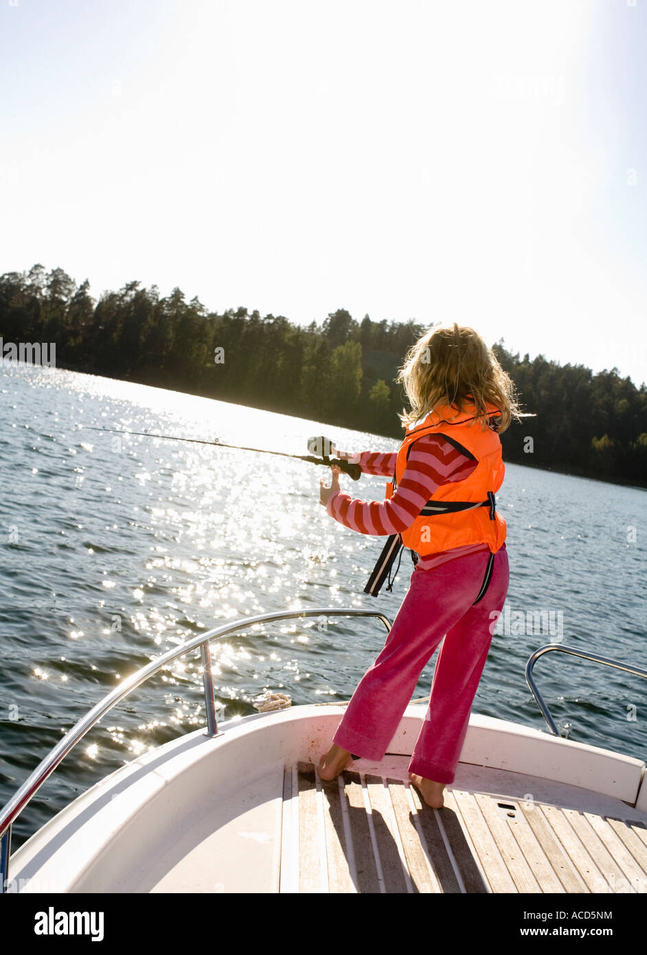 A girl fishing from a boat. Stock Photo