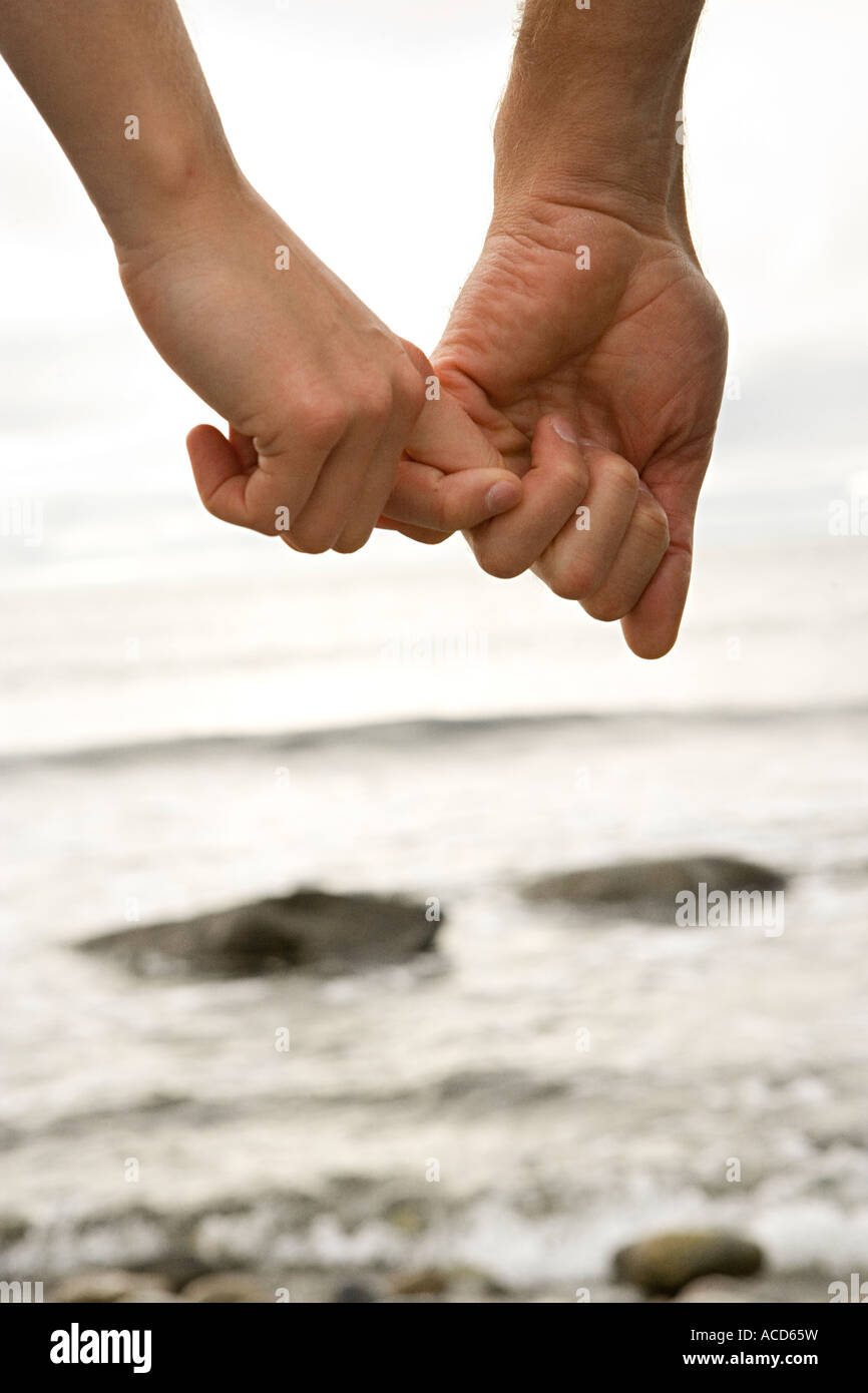 The hands of a couple holding hands by the sea Stock Photo - Alamy