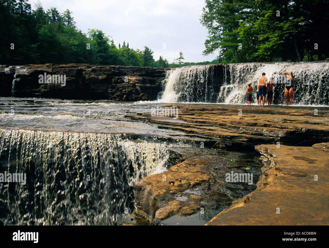 Family cooling off in summer at lower falls at Tahquamenon ...
