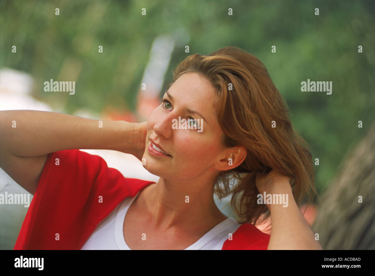 Woman with auburn hair and red sweater in happy mood Stock Photo