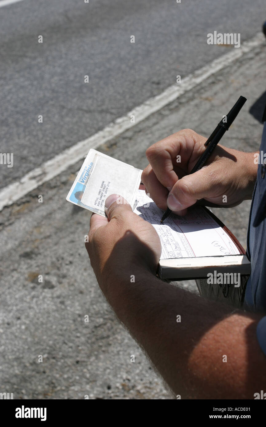 Police officer writing a speeding ticket Construction zone Double fine Kansas City MO PD Stock Photo