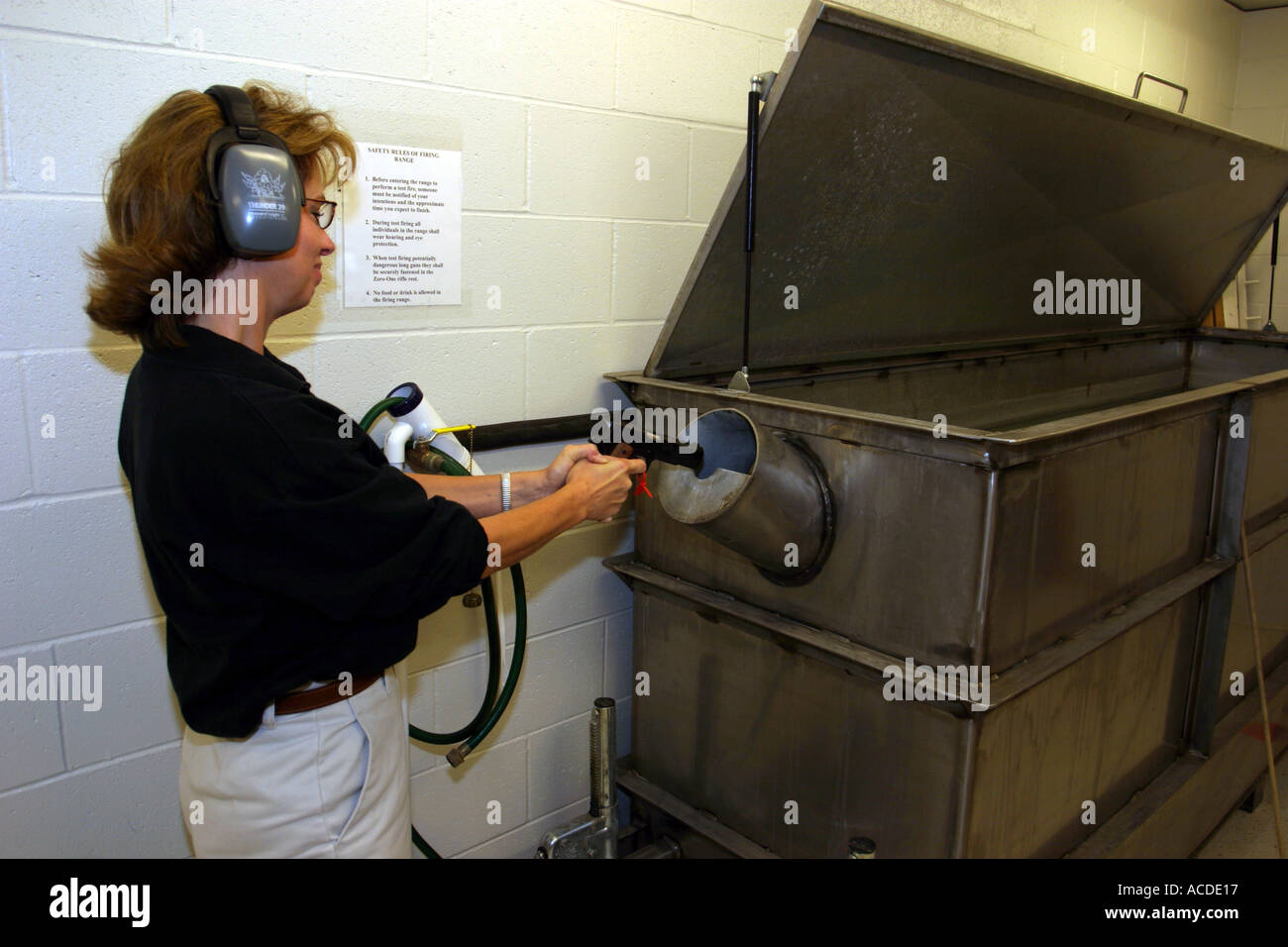 Forensics expert shooting gun into water tank Bullet is later retreived