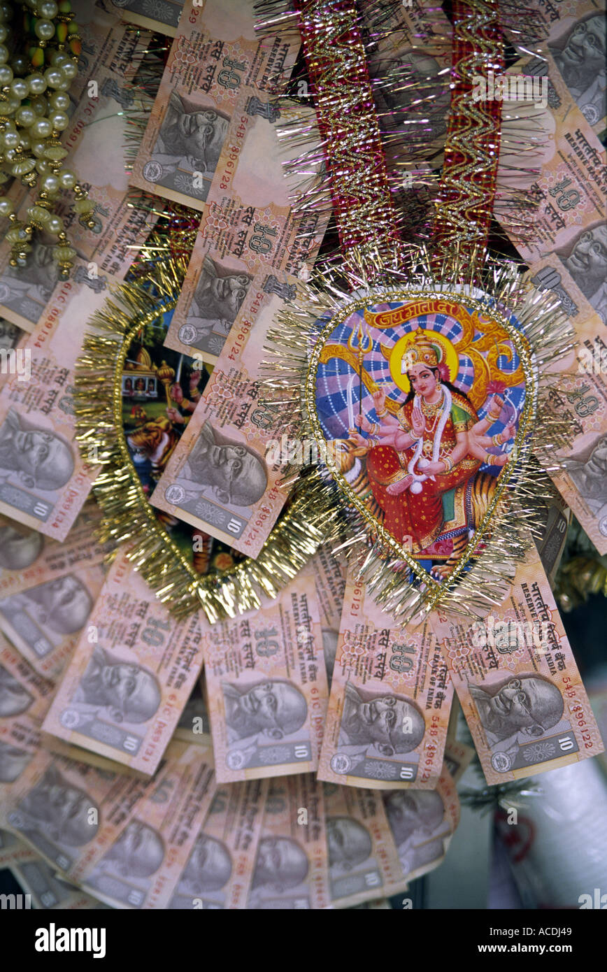Indian Rupee notes arranged as a rosette pattern for a marriage gift; there is also a heart shaped image of an Indian God Stock Photo