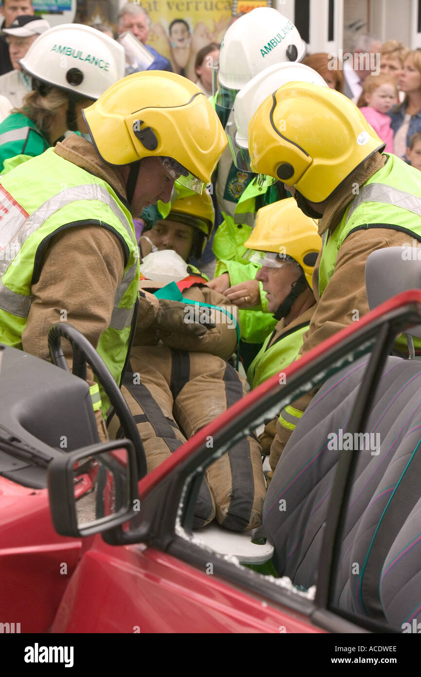ambulance paramedic and firemen treat an injured driver in a car crash scenario training
