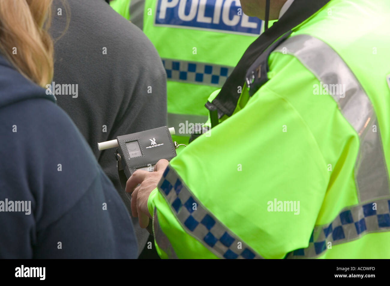 policeman breathalising a member of the public in a road safety training initiative run by Cumbria police Stock Photo