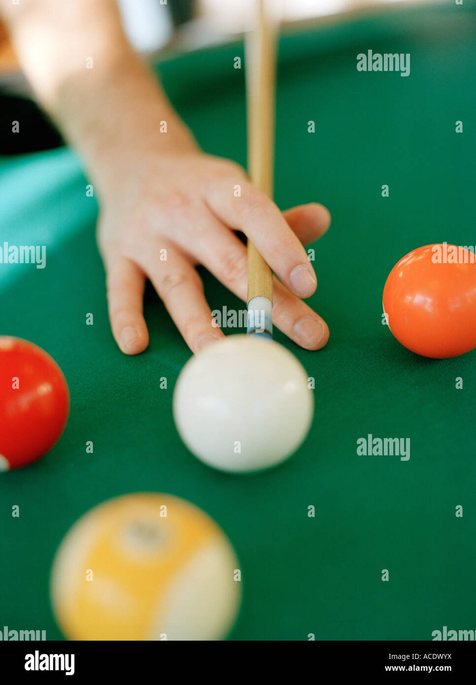 A hand supporting a billiard cue about to play billiards closeup Stock