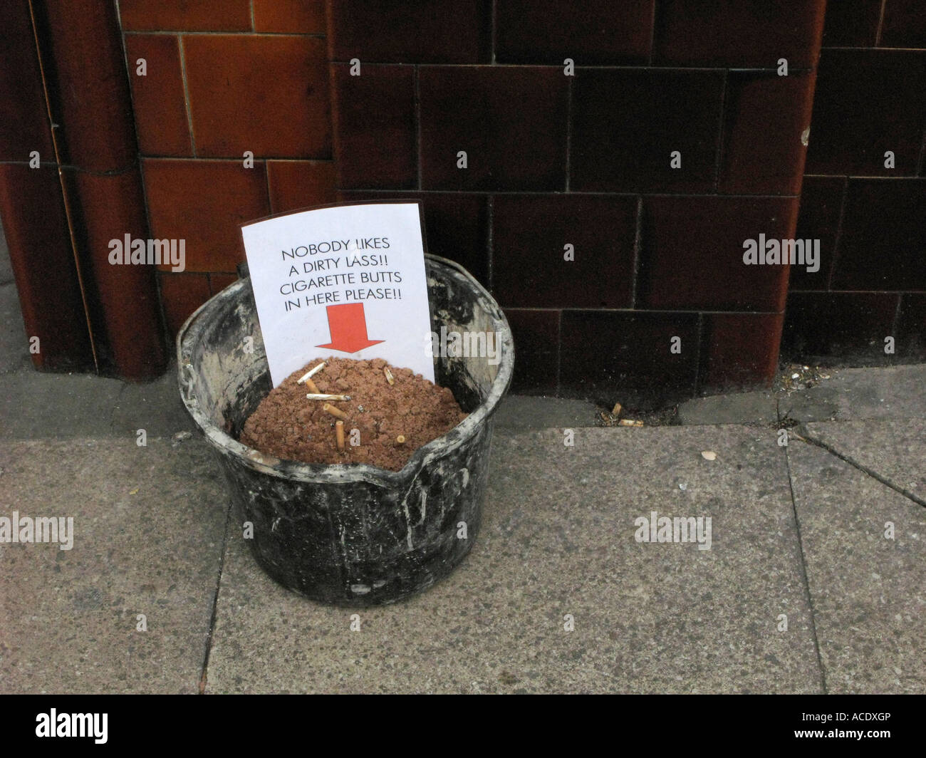 sand bucket outside a pub for used cigarette butts outside public house