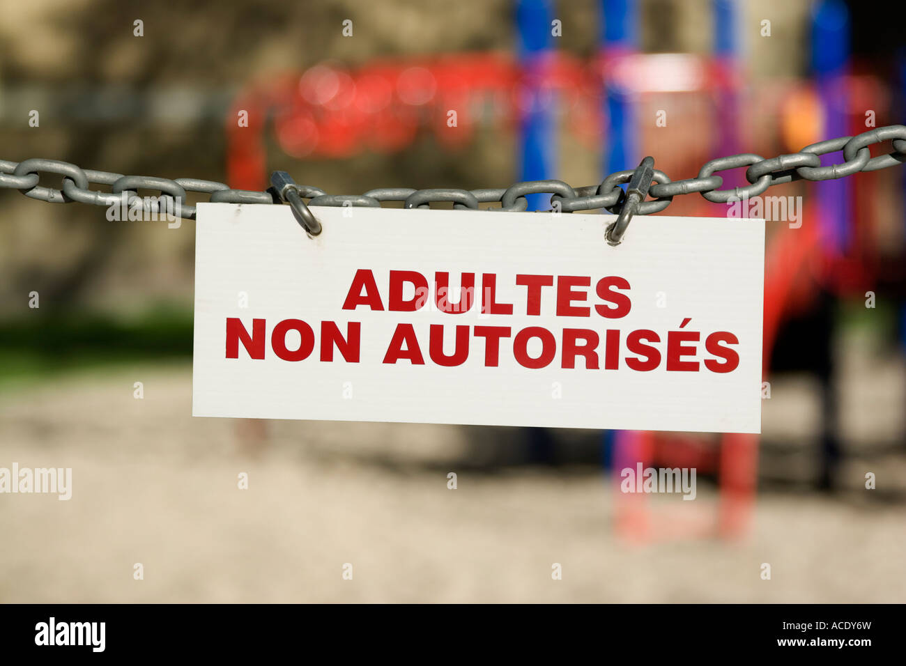 French Adultes Non Autorisés (Adults Not Permitted) sign with playground in background Stock Photo