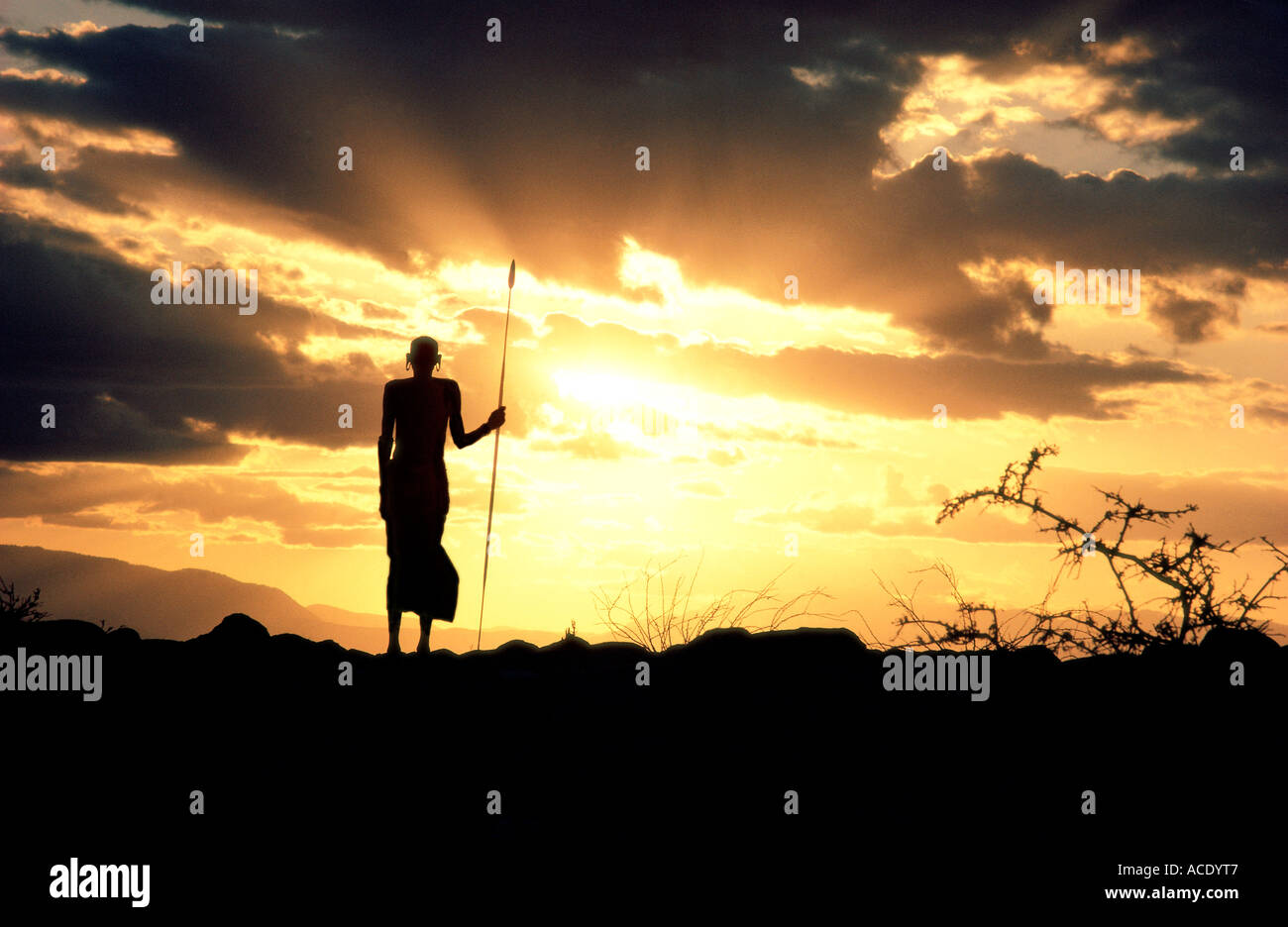 Rendille elder silhouetted against the sunset sky Korr northern Kenya East Africa He is carrying a spear Stock Photo