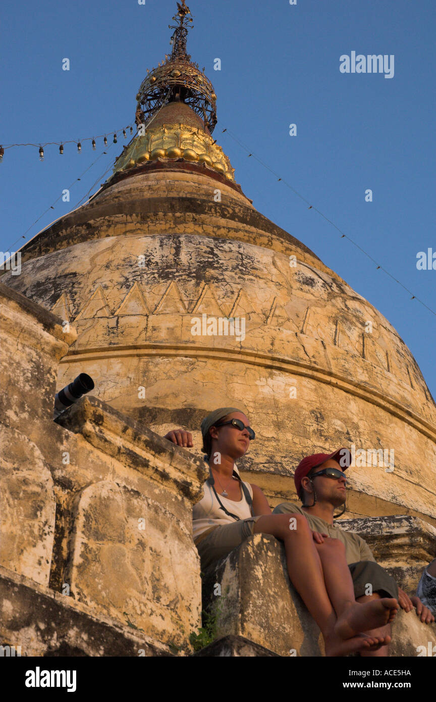 Myanmar Burma Bagan archeological zone more than 4000 temples in a bend of the Ayeyarwady river tourist couple seating under a s Stock Photo