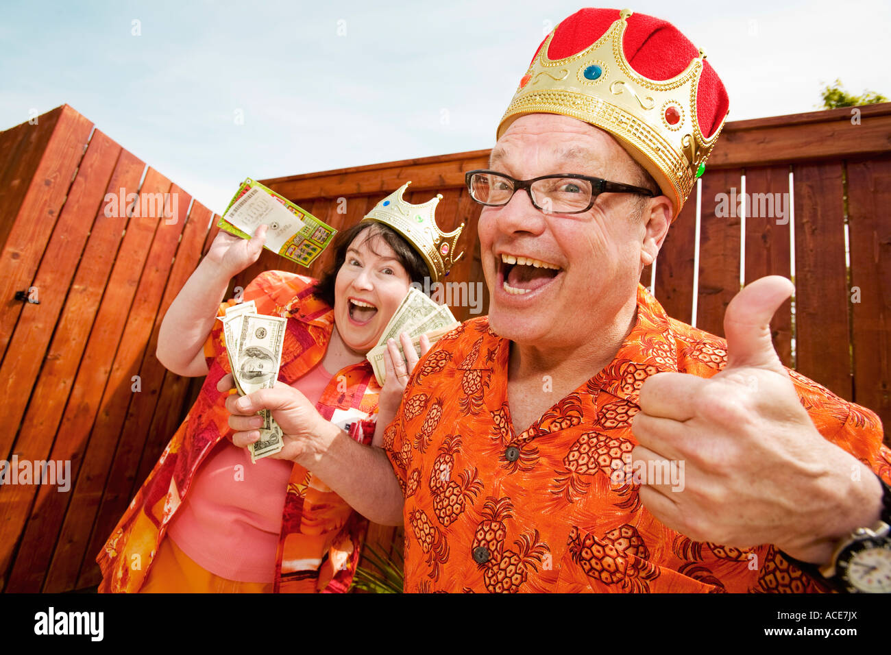 Couple in festive outfits and crowns Stock Photo